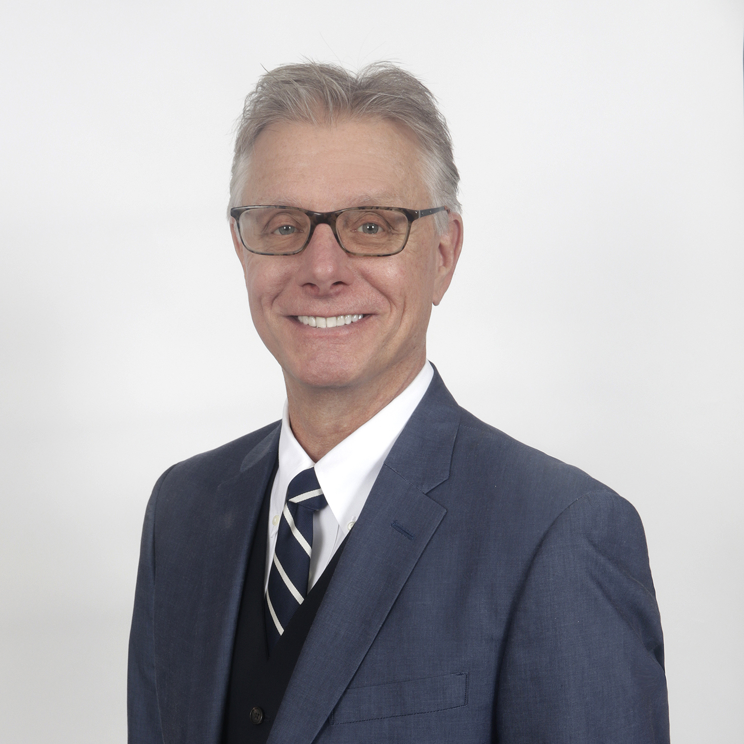 Professional headshot of Monroe County, PA Realtor Robert Hoffman wearing a blue suit, striped tie, and glasses against a clean white studio background.